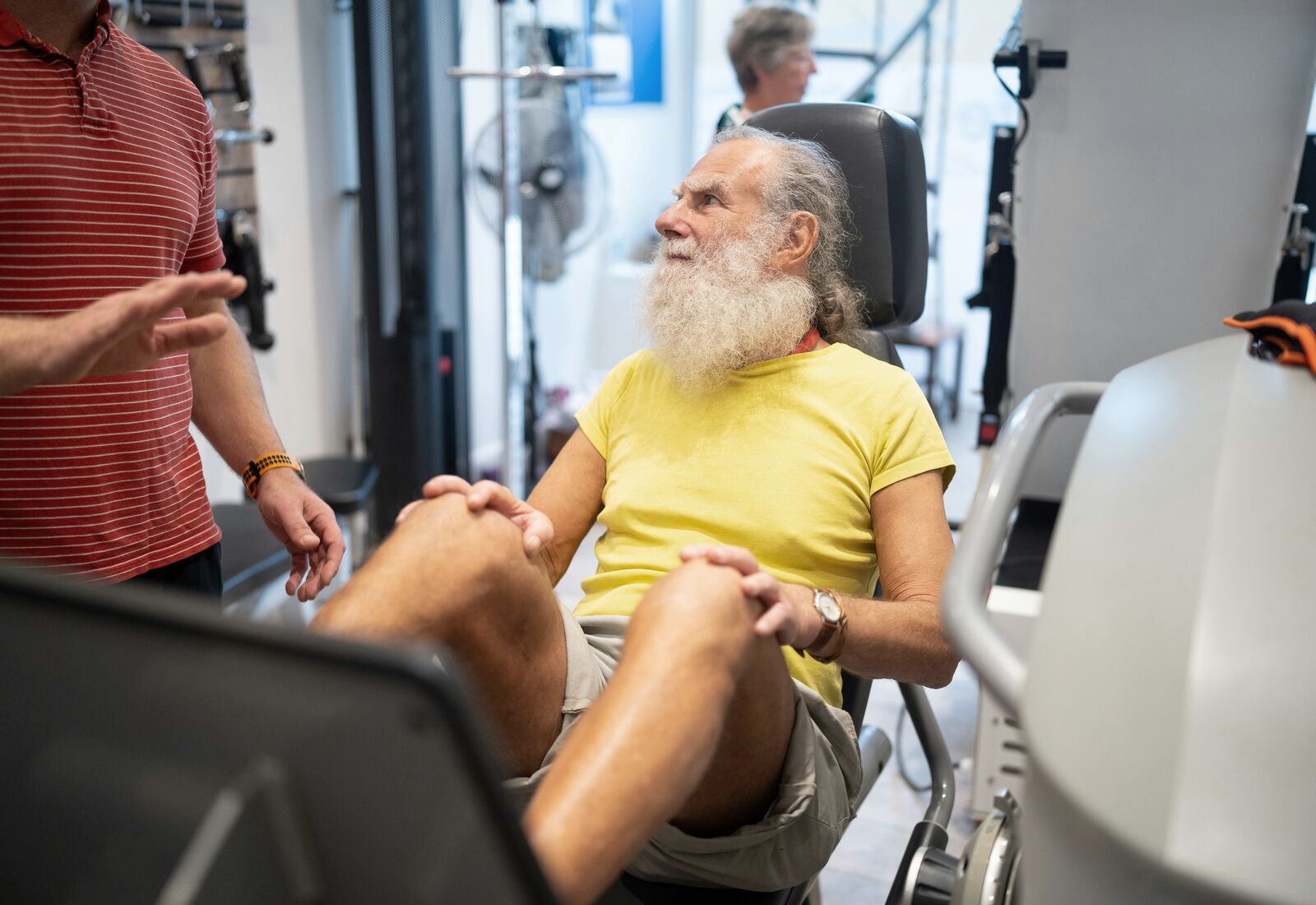 An older adult exercising while talking with a health professional